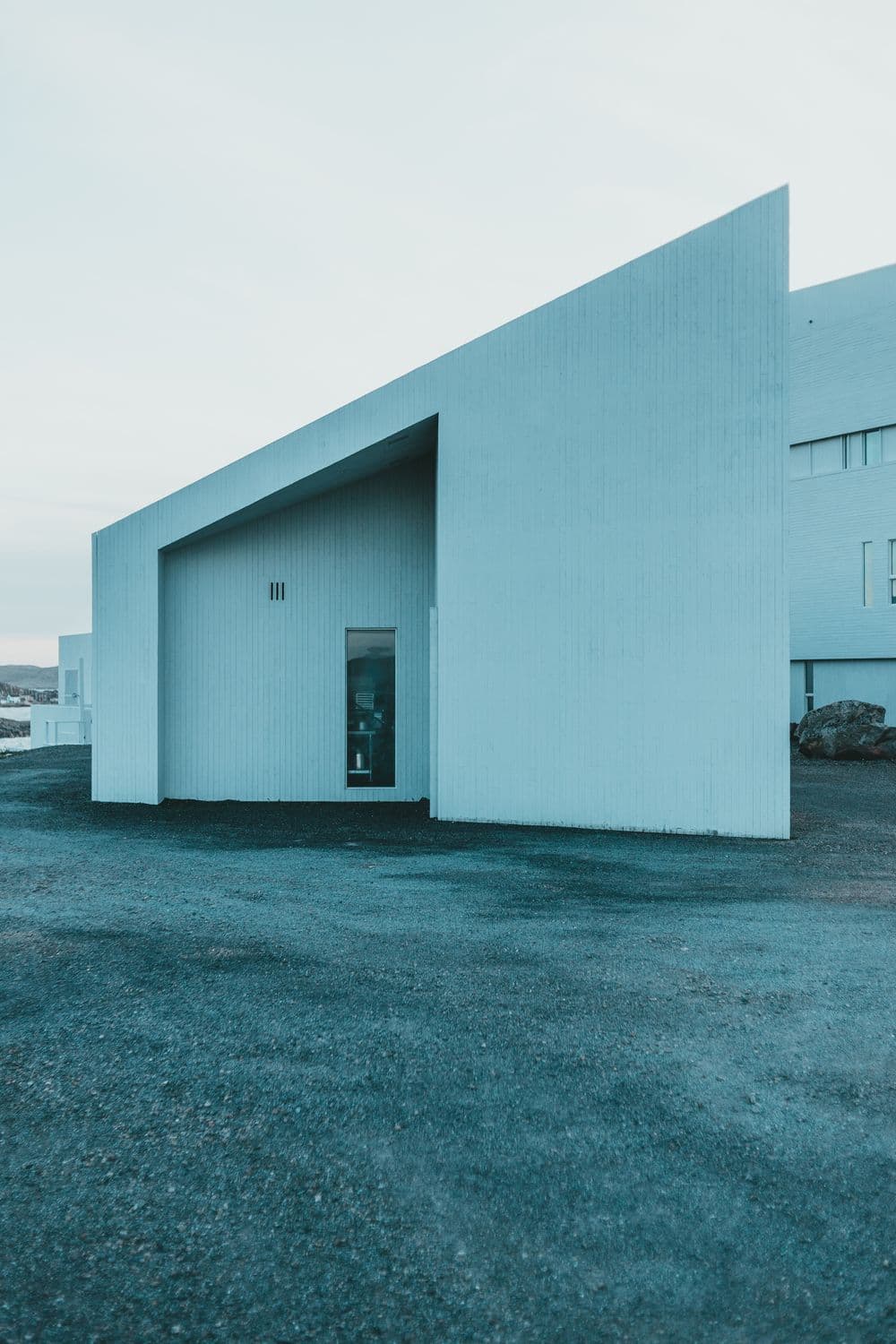 Minimal pale building form against a clear sky
